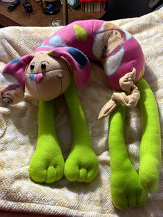 two stuffed animals laying on top of a bed next to each other in the shape of a caterpillar