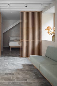 a living room filled with furniture and wooden slats on the wall next to a bed