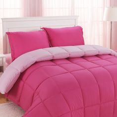 a bright pink comforter and pillows in a bedroom