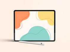 a laptop with a pen on top of it next to an image of abstract shapes