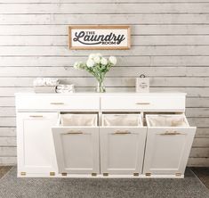 a white cabinet with four drawers and two baskets in front of it, next to a sign that says laundry room