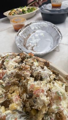 a pizza with lots of toppings sitting on top of a table next to other plates