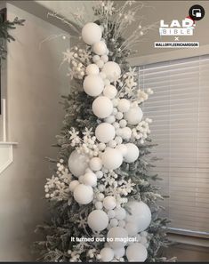 a christmas tree decorated with white balls and snowflakes