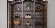 an old china cabinet with glass doors and shelves filled with dishes, cups, and other items