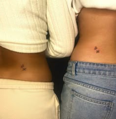 two women with small tattoos on their stomachs, one is showing her lower body