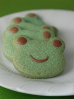 three cookies shaped like frogs on a plate