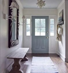 an entryway with a bench and blue door