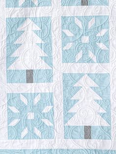 a blue and white quilt with trees on it