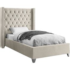 a bed with a tufted headboard and foot board in grey velvet upholstered