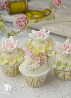 cupcakes decorated with white frosting and pink flowers on a glass platter