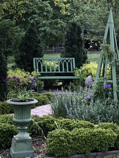 a green bench sitting in the middle of a garden