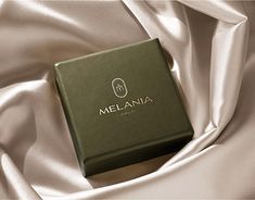 a box that is on top of a white cloth with the name melania