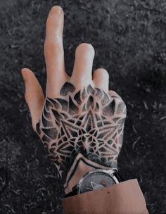 a person's hand with an intricate tattoo on it and the palm of their left hand