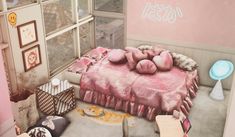 a bed with pink sheets and pillows in a room next to a window that has pictures on the wall