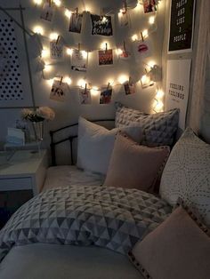 a bedroom with lights strung from the ceiling and pictures on the wall above the bed