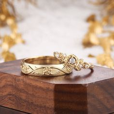 two gold wedding rings sitting on top of a wooden box