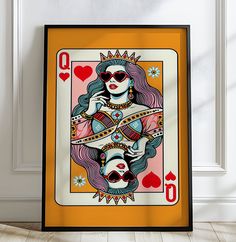 the queen of hearts playing card is on display in front of a white wall and wooden floor