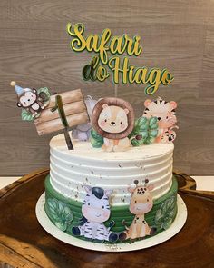 a cake with animals on it and a sign that says safari do hago in the middle