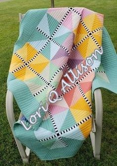 a colorful blanket sitting on top of a lawn chair in the grass with words written on it