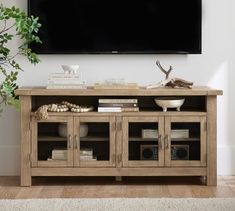 a television is mounted on the wall above a wooden entertainment center