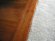 a cat is sitting on the floor next to a wooden shelf and white rugs