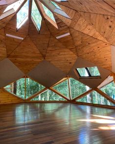 an empty room with wooden walls and windows on the ceiling is lit by bright sunlight