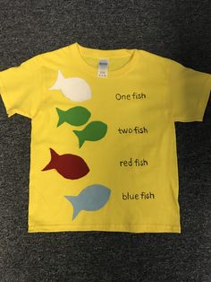 a child's yellow t - shirt with fish on the front and one fish on the back