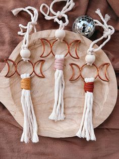 three pieces of jewelry on a plate with beads and tassels hanging from it