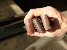 a person holding three pieces of wood in their hand