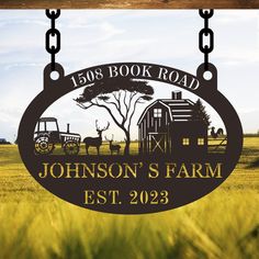 the sign for johnson's farm is hanging from chains in front of an open field