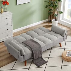 a gray couch sitting on top of a white rug