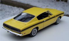 a yellow model car sitting on top of a white table