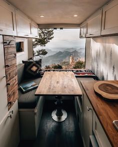 the interior of a camper with a wooden table and bench