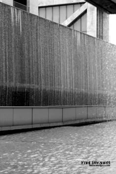 black and white photograph of a man walking in the rain