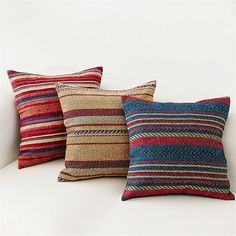 three colorful pillows on a white couch