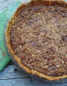 a pie sitting on top of a wooden table next to a green napkin and fork