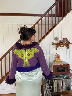 "Penny Lane Luna Magic Sweater with a tie  Step into the world of bohemian style with this beautiful handmade crochet Luna Moth Penny Lane Sweater 🦋 in purple and green hippie style! 🌿🌸 Crafted with love and care, this stunning sweater is designed to be both stylish and comfortable. The intricate crochet pattern creates a beautiful luna moth design that adds a touch of whimsy to the overall look. The purple and green color palette is perfect for those who love to experiment with bold and vibrant colors. 💜💚 The Penny Lane style is a classic bohemian silhouette that features long, flowing sleeves and a relaxed fit, making it perfect for layering over your favorite maxi dress or pair of bell bottoms. The sweater is handmade with high-quality yarn to ensure a durable and long-lasting piec Whimsical Knitting, Purple And Green Color Palette, Luna Moth Design, Maximalist Fashion Style, Moth Design, Hippie Sweaters, Green Color Palette, Flowing Sleeves, Hippie Crochet