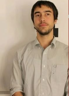 a man standing in front of a white wall