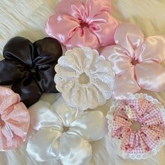 several different types of scrunffles on a white sheet with pink and black bows