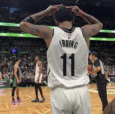 a man standing on top of a basketball court holding his hands up to his head