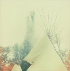 an old photo of a teepee tent with trees in the backgroup