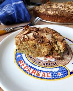 a piece of cake sitting on top of a white plate next to a blue and yellow napkin