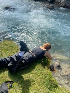 a person laying on the ground next to some water