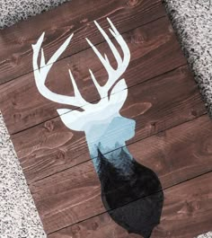 a wooden sign with a deer's head painted on it