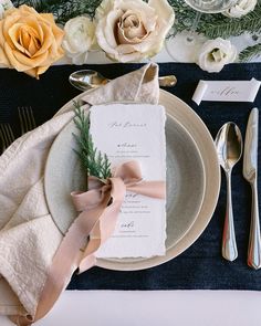 a place setting with napkins, silverware and flowers