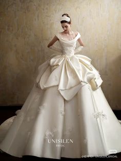 a woman in a white wedding dress is posing for the camera