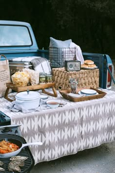 a picnic table with food on it next to a truck