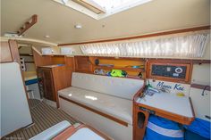 the inside of a sailboat with white couches and wooden trim on the walls