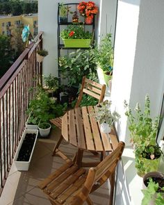 a balcony with potted plants and wooden chairs