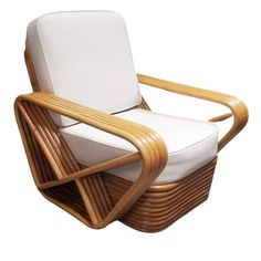 a chair made out of wicker and leather with a white cushion on the back